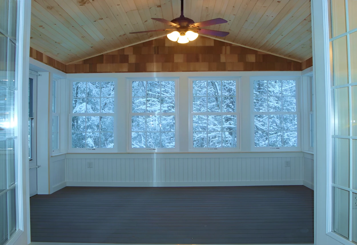 Wood-paneled sunroom with winter view outside.