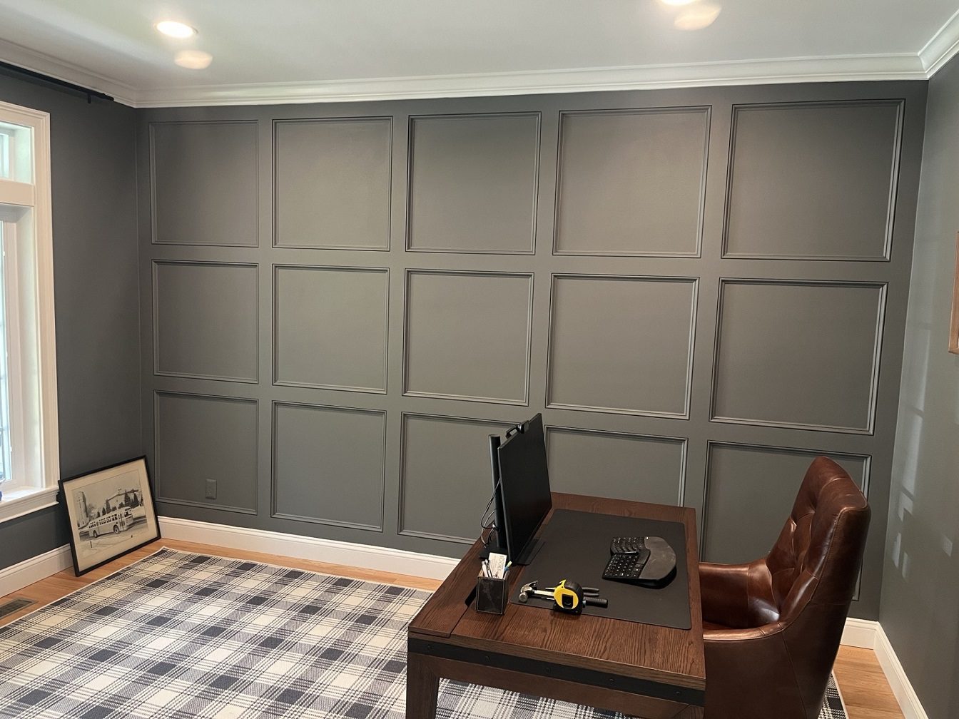 Cozy workspace with plaid carpet and window.